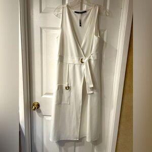 Modern white, wrap style dress with gold detailing.
